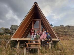 瓦拉斯mountain view willcacocha lodge的一群儿童坐在三角形的房子里