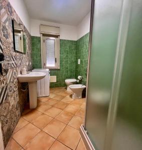 切法卢Cefalù Suite的浴室设有水槽、卫生间和绿色瓷砖。