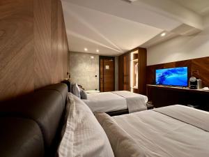 莱斯拉塞斯Hôtel Restaurant & Spa Les Planets的酒店客房设有两张床和一台平面电视。
