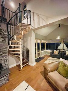卡索曼Conree Lodge的客厅设有螺旋楼梯和沙发