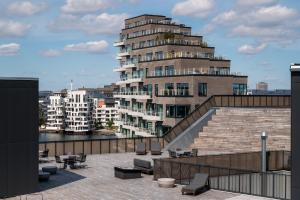 哥本哈根The Pier Ateliers by Daniel&Jacob's的一座带楼梯的大型公寓楼和一座建筑