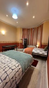伦敦25 Minutes to Central London Rooms 35的酒店客房设有两张床和一张桌子。