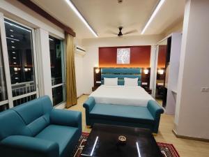 勒克瑙The Grace Residency, Lucknow的一间卧室配有一张床和两张蓝色椅子