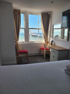 布莱顿霍夫大西洋海滨酒店的卧室配有一张床、一张书桌和窗户。
