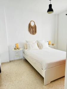 桑卢卡尔-德巴拉梅达Ático en Sanlúcar de Barrameda的白色的卧室设有白色的床和白色的墙壁