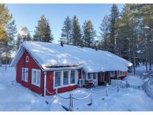 鲁卡Villa Kiviaapa in Ruka Kuusamo的屋顶上积雪的红色房子