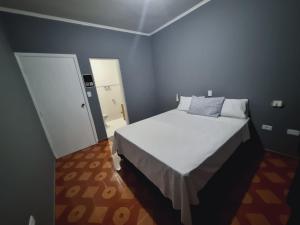 瓜鲁柳斯Villa Fátima Hostel GRU的卧室配有白色的床和门