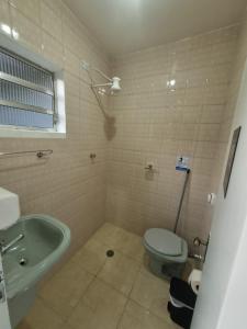 瓜鲁柳斯Villa Fátima Hostel GRU的浴室配有卫生间、盥洗盆和浴缸。