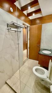 勒克瑙The Grace Residency, Lucknow的一间带卫生间和玻璃淋浴间的浴室