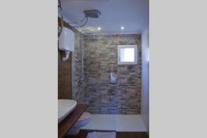 乌尔齐尼Mavric Cabin的带淋浴的浴室(带石墙)