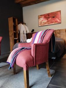 Vista FloresFinca La Valletana的一间卧室配有椅子,上面有毯子