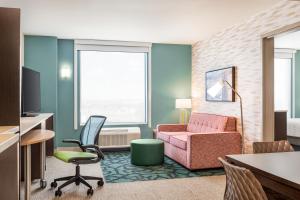 夏延Home2 Suites By Hilton Cheyenne的酒店客房带椅子和沙发