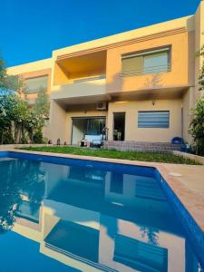 马拉喀什New villa in Marrakech palmeraie的一座房子前面设有游泳池