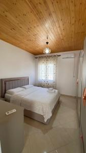 KomanLugina e Komanit的一间卧室设有一张带木制天花板的大床