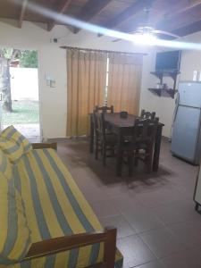 瓜莱瓜伊Bungalows Gualeguay的配有桌椅和电视的客房