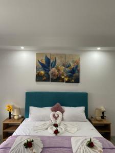 莫斯塔尔Apartman Pranić的一间卧室,床上放着两朵鲜花