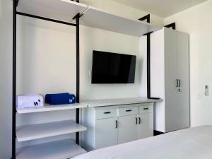 卡塔赫纳Wonderful 2BR with impressive view的卧室配有白色橱柜和墙上的电视。