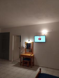 阿齐亚佩拉加克里塔日光公寓酒店的一间设有一张桌子和一台墙上的电视的房间