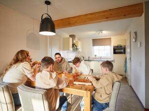 罗赫尔Cozy, child-friendly villa with a sauna in Limburg的一群坐在桌子旁吃饭的人