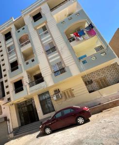 赫尔格达Apartment Hossam 1的停在大楼前的红色汽车