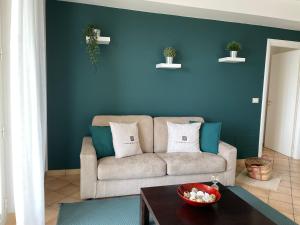 陶尔米纳Taormina Rooms Panoramic Apartments的带沙发和蓝色墙壁的客厅
