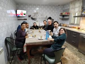 萨里亚Pensión Casa do Gallo Sarria的一群人坐在厨房的桌子旁