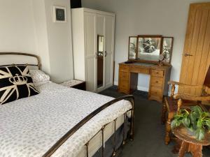 BredonPrivate Room in a house in the Cotswolds的一间卧室配有床、镜子和梳妆台