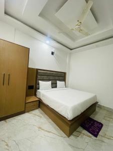 马图拉Hotel City Star Family Stay的卧室配有白色的床和木制橱柜。