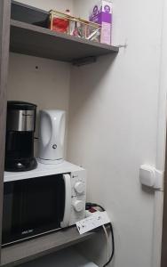 尼姆Chambre spacieuse dressing WC et SDB communes的架子上的微波炉,上面有咖啡壶