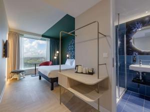 鹿特丹ibis Styles Rotterdam Ahoy的一间卧室配有一张床,浴室设有水槽
