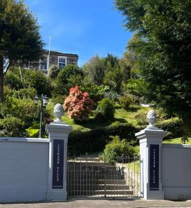 罗撒西Ivybank Villa的上面有两座雕像的白色栅栏