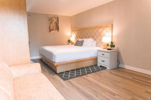 克利尔沃特Hotel Civilia Lakeside by Civilia Golf Retreat的一间卧室配有一张大床和一张沙发