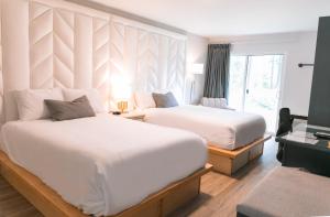 克利尔沃特Hotel Civilia Lakeside by Civilia Golf Retreat的酒店客房设有两张床和窗户。