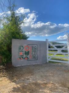 圣罗克Vila Eco Mobili的栅栏旁的白色门,上面有标志