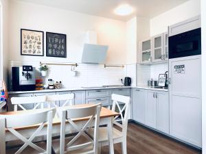 雷克雅未克云游客栈的厨房配有白色橱柜和桌椅