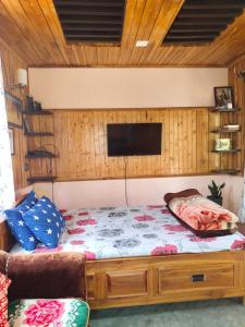 大吉岭Eviana homestay的卧室配有一张床铺,墙上配有电视