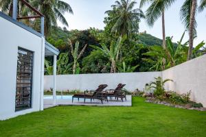 波拉波拉Hidden Villas by Matira Beach的后院设有两把椅子和游泳池