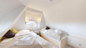 赫尔努姆Haus Weststrand的阁楼卧室设有两张床和窗户。