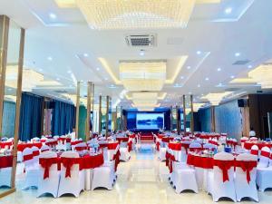 Anh SơnKHÁCH SẠN KIM NHAN的宴会厅配有红色和白色的桌椅