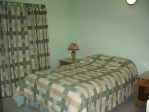 卡斯特里Anne Marie Villas的一间卧室配有一张床和一张桌子上的台灯