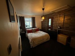 伍尔弗汉普顿Shropshire Guesthouse的一间卧室设有一张床和砖墙