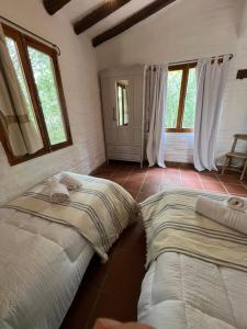 拉库布蕾Cabañas Lomita San Luis的配有窗户的客房内的两张床