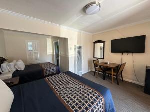 米尔谷塔马尔派斯汽车旅馆的一间酒店客房,设有两张床、一张桌子和一台电视机