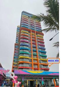 Nam KhêFlamingo Ibiza Hải Tiến的一座高大的建筑,上面有色彩缤纷的阳台