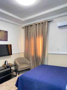 东勒贡EL Apartment的一间卧室配有蓝色的床和椅子
