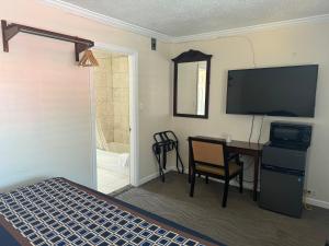 米尔谷塔马尔派斯汽车旅馆的一间卧室配有一张床、一张书桌和一台电视