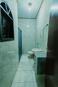 圣安东尼奥-杜皮尼亚尔Pousada São Benedito的白色的浴室设有卫生间和水槽。
