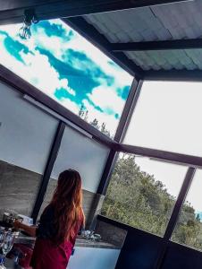 拉塔昆加SUITE STARS的坐在柜台上,从窗户望出去的女人