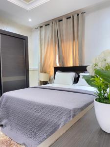 东勒贡EL Apartment的一间卧室配有一张大床和植物