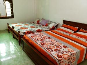 贾夫纳Nallur Mylooran Arangam的卧室内两张并排的床
